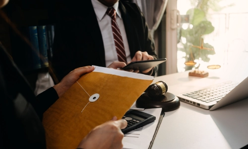 A lawyer holding an important document, and beside him is another lawyer reviewing a case on a tablet.