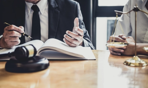 A lawyer sitting beside a client while explaining the details of a case to the client