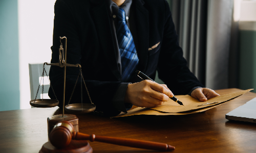 An Albany Business Formation Lawyer looking at business documents in his office while sitting behind a desk.