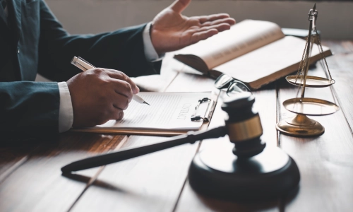 An Albany Car Accident Lawyer gesturing towards a client while talking about details regarding some case files on the table