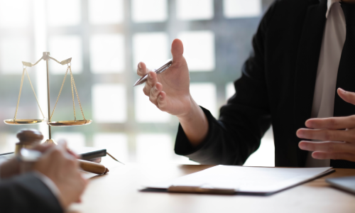 New York business dispute lawyers discussing the details of a case while sitting across from each other at a table.
