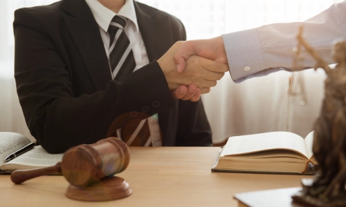A New York real estate lawyer shaking hands with a client visiting his office.