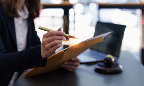 A New York Traffic Ticket Lawyer reviewing an envelope of case files and signing documents.