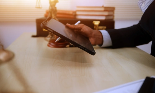 A New York Truck Accident Lawyer reading notes on a tablet while sitting in his office.