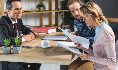 A couple consulting with an Albany car accident lawyer about the settlement process for their accident case.