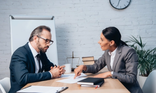 An Albany estate planning attorney points to a document while explaining estate planning strategies in New York to a client.